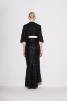 Black sequined cropped top by Lili Blanc, shown from the back with shimmering sparkle and fitted design.