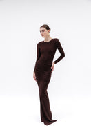 Brown Azalea maxi skirt by Studio NK, flowing fabric with a relaxed fit, shown on a model in a natural outdoor setting.