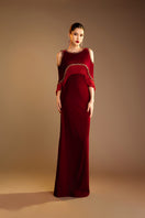 Red Valenciani gown with shoulder cutouts, elegant cape dress featuring a sophisticated and stylish design for formal occasions.