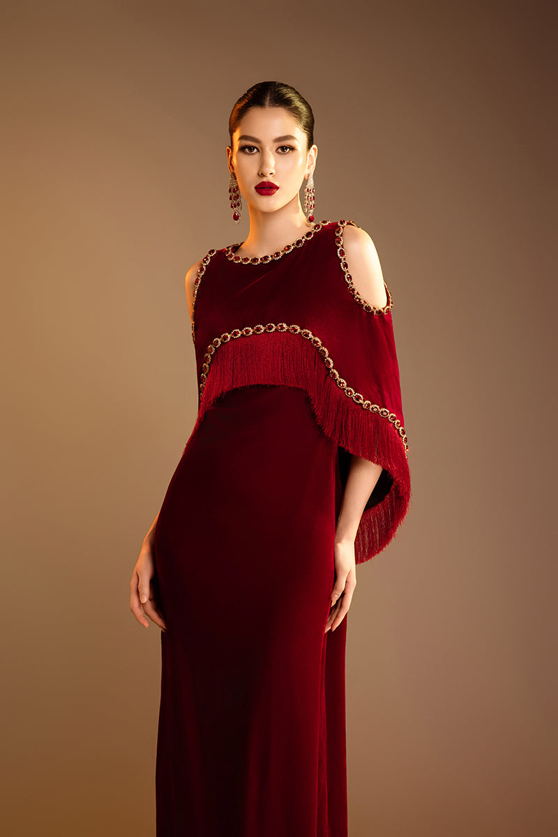 Red Valenciani shoulder cutouts cape gown featuring elegant draping and statement sleeves, perfect for formal occasions.