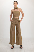 A pair of ANA + MARIA ACAR pants in apple cinnamon color, featuring a relaxed fit and stylish design, shown on a model.