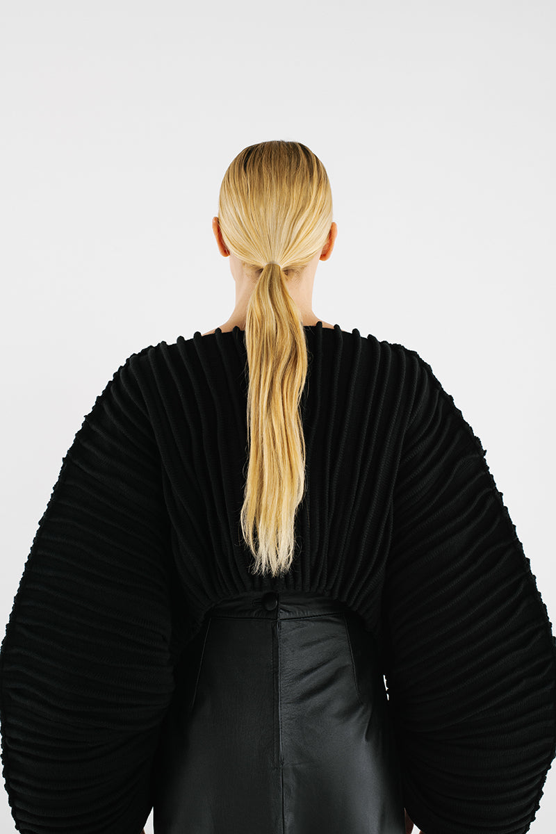Black accordion snail sweater by MAZ Manuela Álvarez, featuring textured, layered fabric design in a cozy, stylish sweater silhouette.