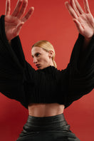 Black accordion snail sweater by MAZ Manuela Álvarez featuring textured, ruffled design and long sleeves.