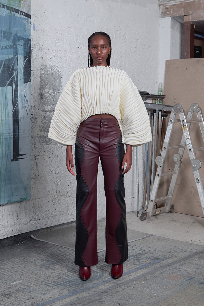 Maz Manuela Álvarez ivory accordion snail sweater displayed on a hanger with textured fabric and ribbed details.