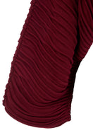 Wine red accordion snail sweater by MAZ Manuela Álvarez featuring textured, layered knit design on a cozy sweater.