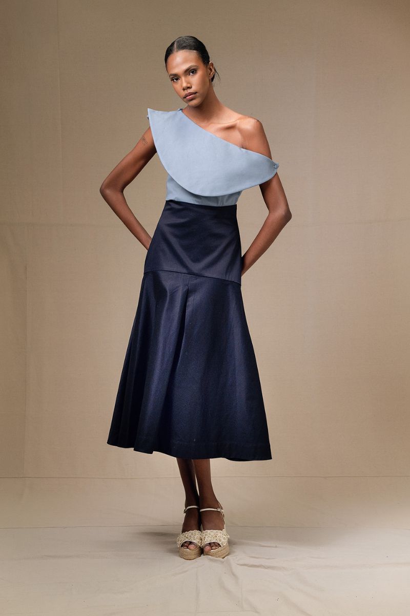 Navy blue ADA midi skirt by ANA + MARIA displayed on a model, showcasing its flowy fabric and elegant design.