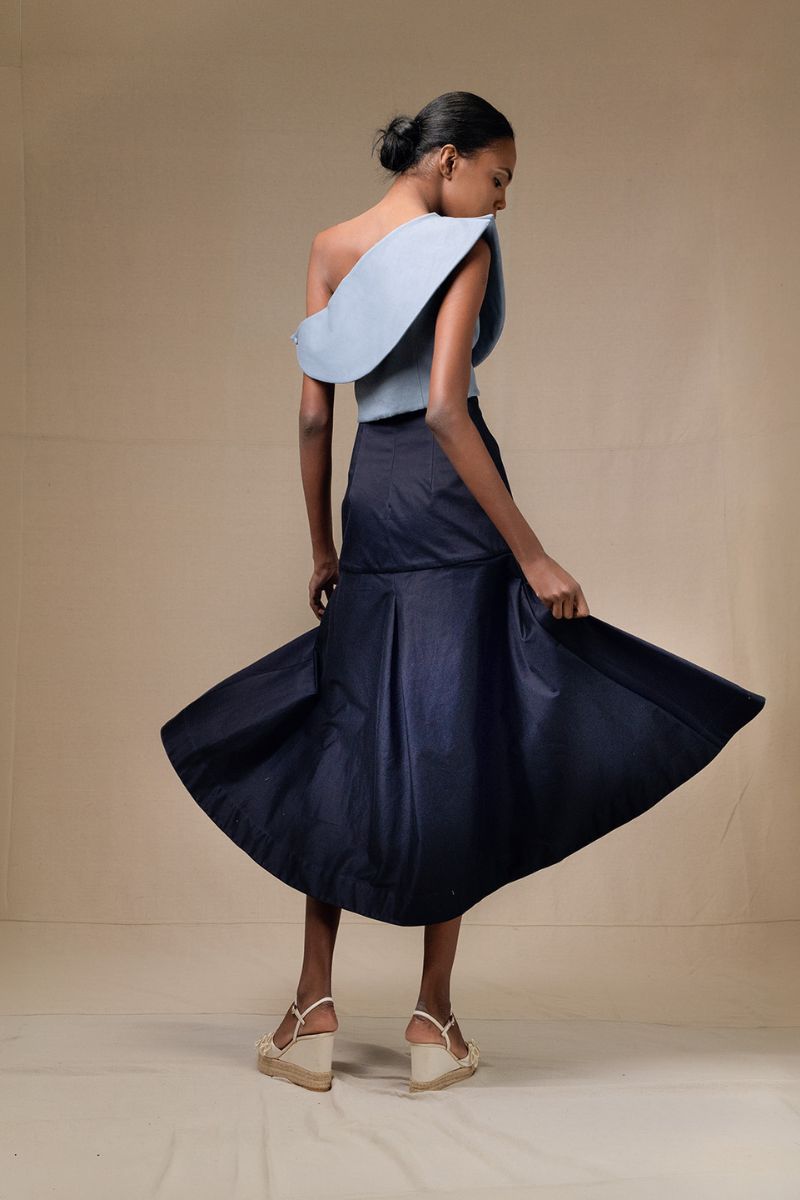 Navy blue Ada midi skirt by ANA + MARIA, shown with a smooth fabric and a flattering, flowy silhouette on a white background.
