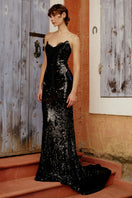 Elegant black KATIE gown by Gigii's, featuring flowing fabric and intricate detailing, perfect for formal occasions.