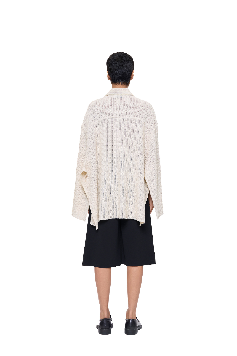 Back view of URA Alfie Cape in ivory, stylish shirt with cape detail, showcasing elegant design and fabric texture.