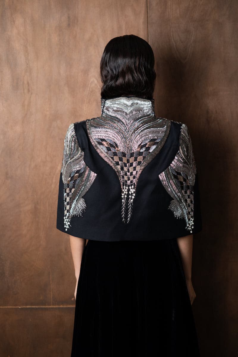 Nadya Shah All About Eve cape jacket with elegant draped design and textured fabric, styled for a sophisticated look.