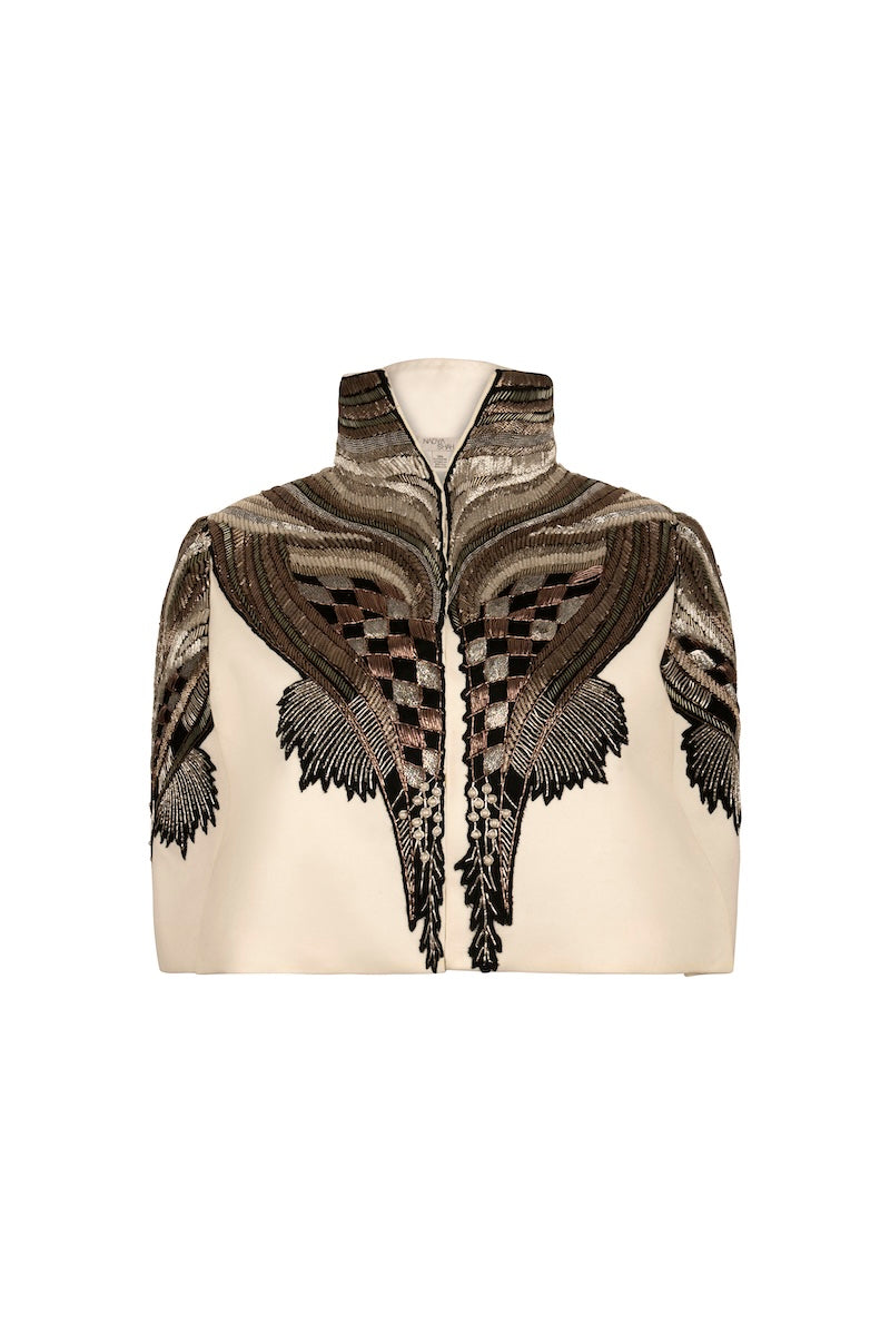 Ivory capelet jacket from Nadya Shah's All About Eve collection displayed on a mannequin.