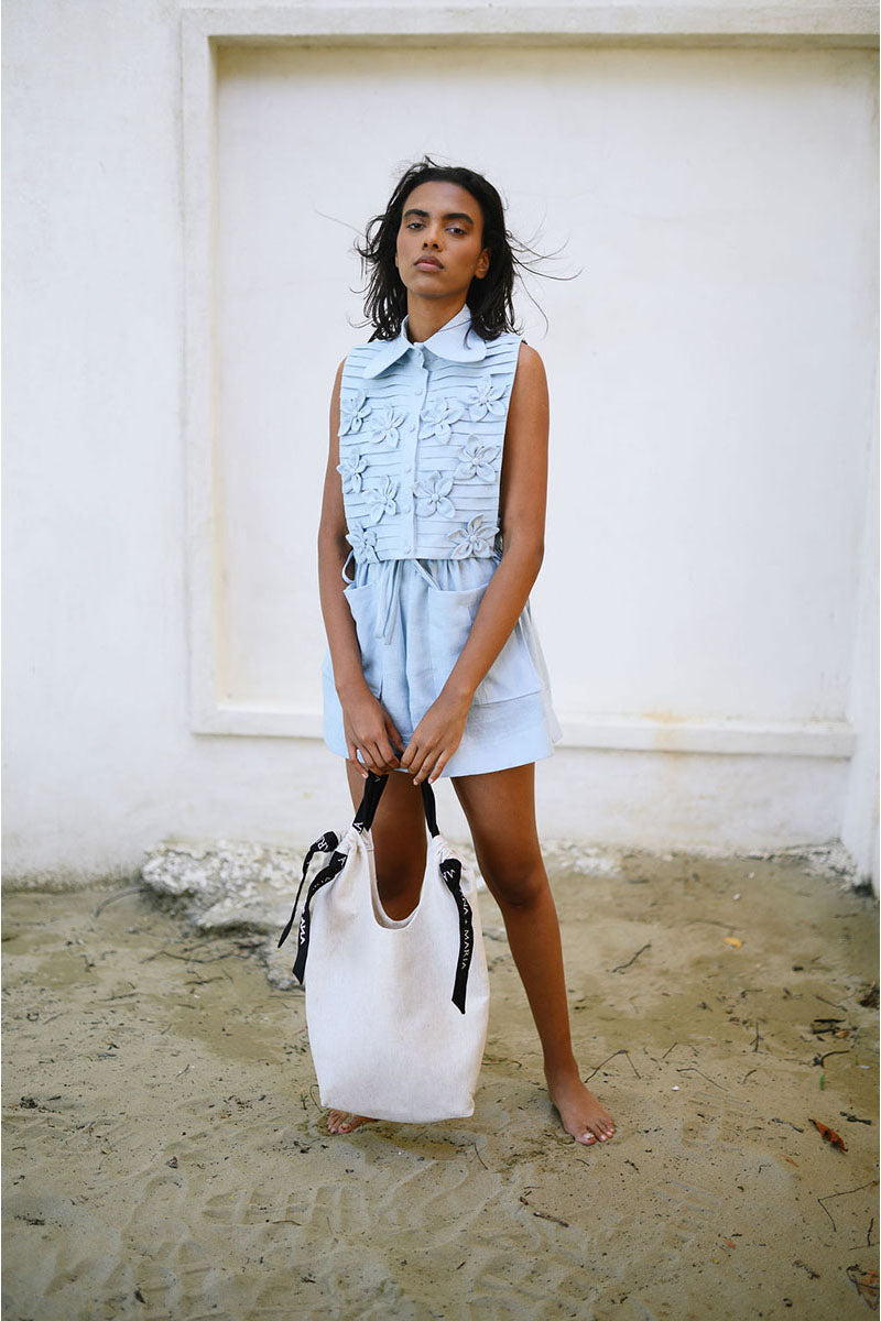 Light blue ALMAR BIB top by ANA + MARIA, featuring a stylish and comfortable design with detailed fabric texture.