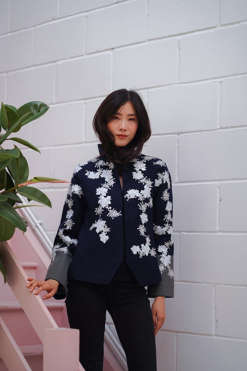 Nadya Shah Alto Mare jacket showing a stylish waterproof jacket with a hood and zipper, perfect for outdoor wear.