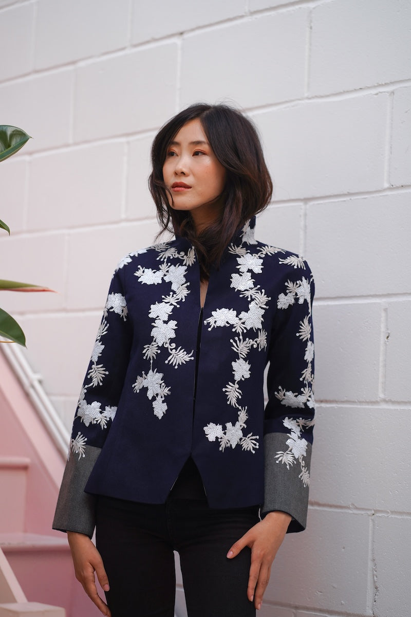Nadya Shah Alto Mare jacket displayed on a hanger, featuring a stylish lightweight design with a zip-up front and hood.