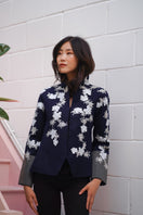 Nadya Shah Alto Mare jacket displayed on a hanger, featuring a stylish, lightweight design with a modern collar and smooth fabric.