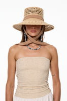 Beige bucket hat by LE SH KA with wide brim and casual style, shown on a model in a close-up outdoor shot.