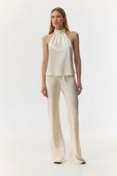 Cream silk satin backless halter-neck top by Serenity, featuring a smooth, shiny fabric and elegant design.