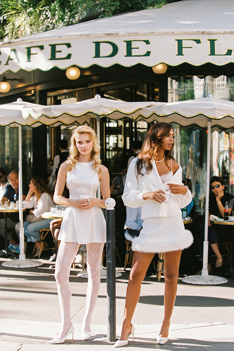 White Nana Jacqueline Anika mini skirt displayed on a model, showcasing its stylish design and lightweight fabric.