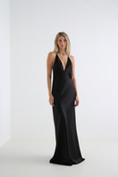 Serenity Anima Black deep V-neck silk-satin maxi dress displayed on a hanger, showcasing its elegant flowing design.