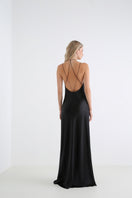 Serenity Anima Black deep V-neck silk-satin maxi dress hanging on a rack, showcasing elegant and flowing evening wear.