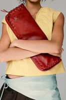 Red leather Annabelle clutch bag by Double A, stylish accessory with a sleek design and textured washed finish.