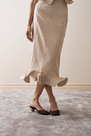 Close-up of YASSMIN SALEH ivory arch midi skirt showcasing its elegant fabric and unique arch design.