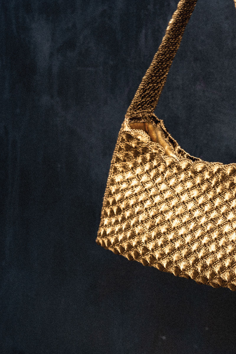Verdi Arista seashell shoulder bag in antique brass with detailed shell design and adjustable strap, stylish and unique accessory.