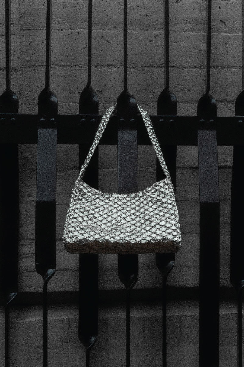 Silver shoulder bag with seashell design from Verdi's Arista collection, featuring a stylish and elegant accessory.