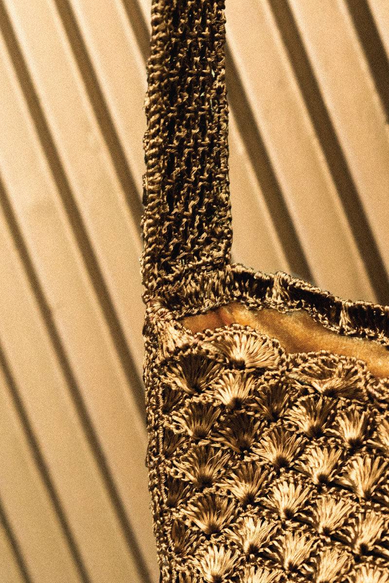 Verdi Arista seashell shoulder bag in antique brass with detailed shell embellishments and a stylish strap.