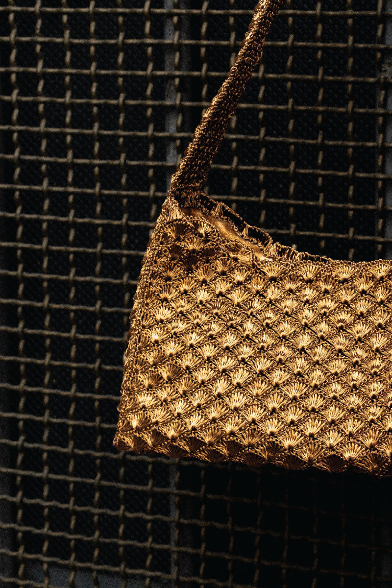 Verdi Arista seashell shoulder bag in antique brass with intricate shell design and adjustable strap.