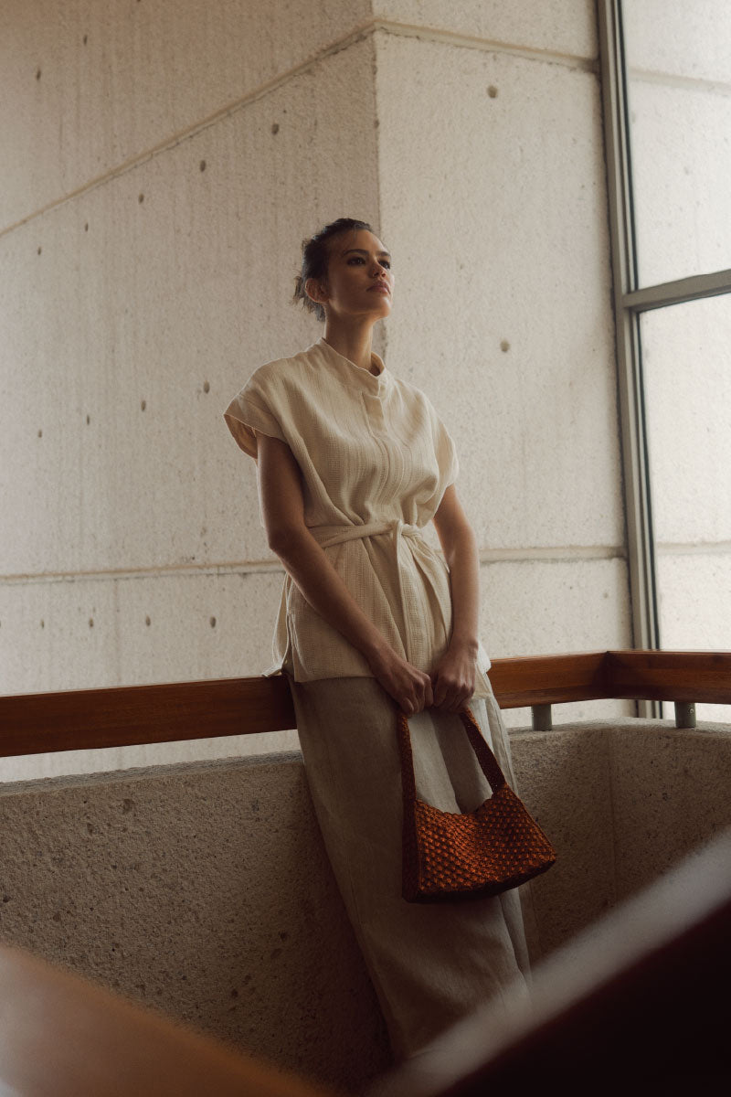 Verdi Arista seashell shoulder bag in copper with textured seashell design on a neutral background.