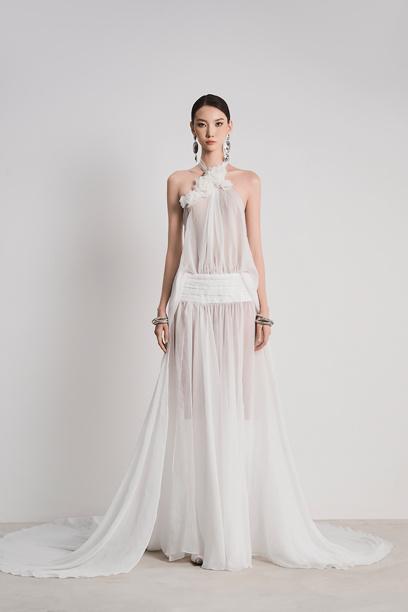 White Glacial Grace gown by Le Thanh Hoa featuring elegant flowing fabric and intricate detailing on the bodice.