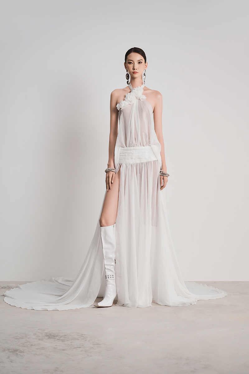 Le Thanh Hoa Glacial Grace gown in white with flowing fabric and elegant design, displayed on a mannequin.