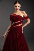 Le Thanh Hoa luminous flame gown with flowing fabric and vibrant red-orange hues, displayed on a mannequin against a neutral background.