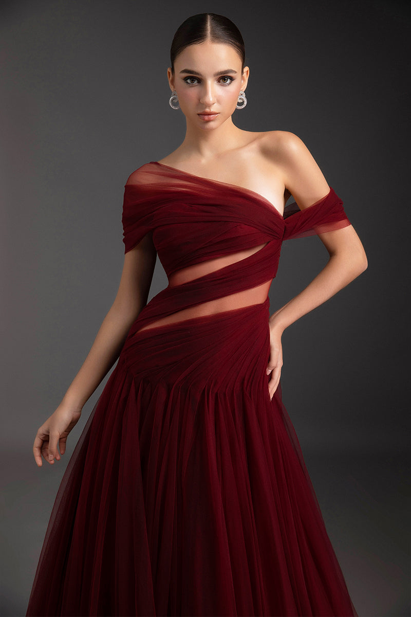 Le Thanh Hoa luminous flame gown with flowing fabric and vibrant red-orange hues, displayed on a mannequin against a neutral background.