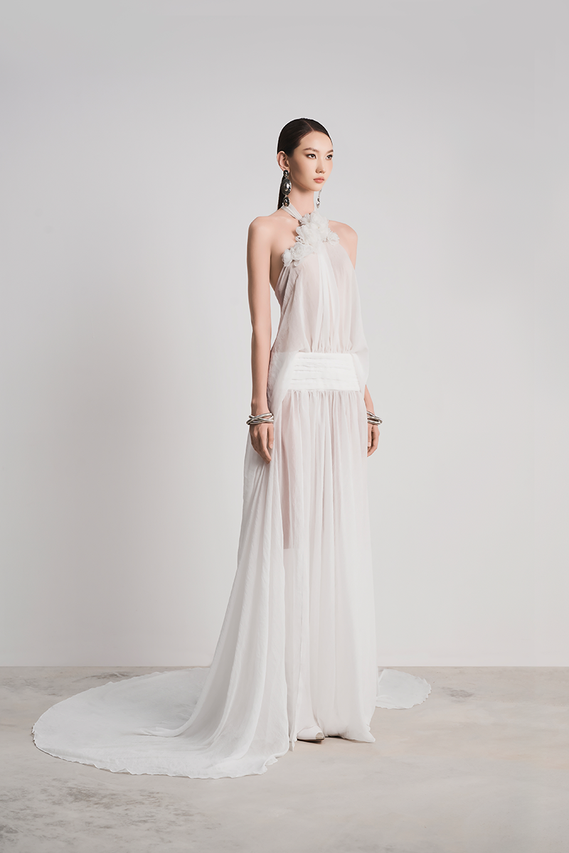 Elegant white Glacial Grace gown by Le Thanh Hoa featuring flowing fabric and intricate detailing.