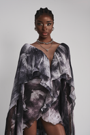 Black Le Thanh Hoa Soaring Doves Maxi Dress displayed on a hanger with flowing fabric and intricate dove pattern.