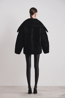 Black Le Thanh Hoa Nightfall quilted coat with padded design, shown on a mannequin, showcasing its stylish and cozy outerwear.