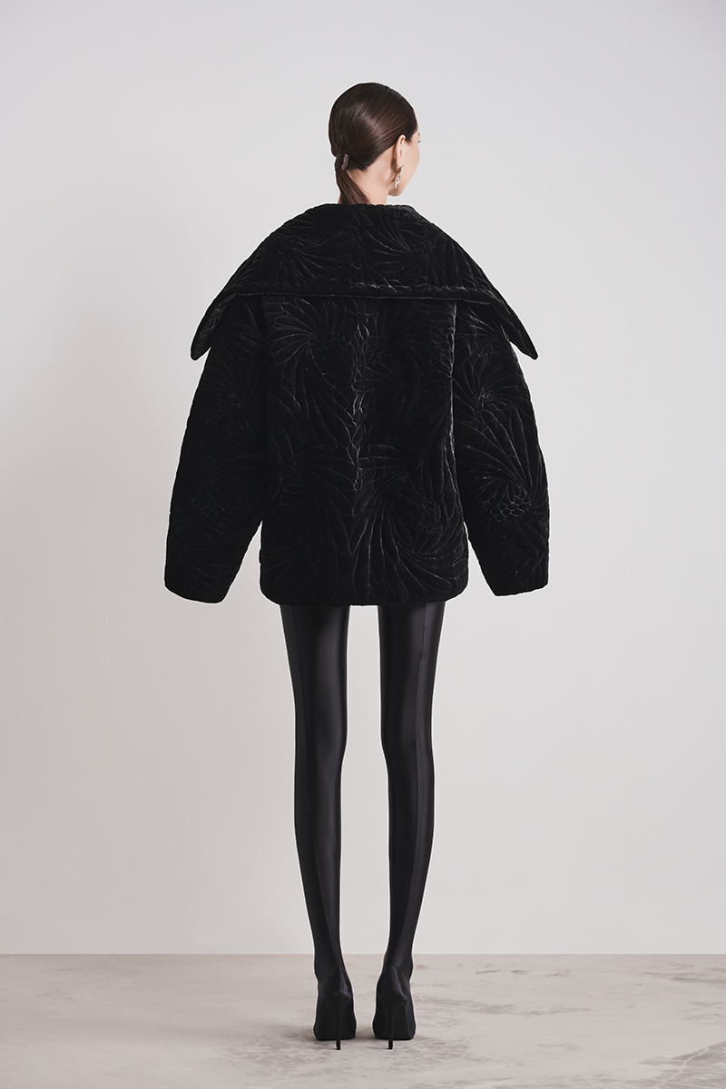 Black Le Thanh Hoa Nightfall quilted coat with padded design, shown on a mannequin, showcasing its stylish and cozy outerwear.