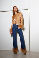 Dark blue Astra Feather denim jeans by Rayane Bacha with honey golden stitching, shown on a model.