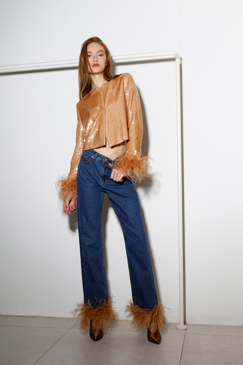 Dark blue Astra Feather denim jeans by Rayane Bacha with honey golden stitching, shown on a model.