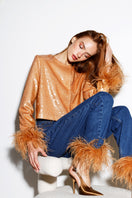 Dark blue Astra Feather denim jeans by Rayane Bacha with honey golden stitching, shown on a model.