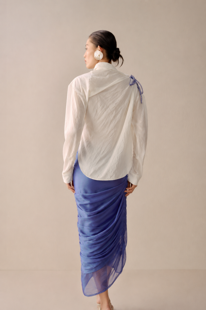 White asymmetric floral shirt by Lecia featuring a stylish, uneven hem and vibrant floral patterns.
