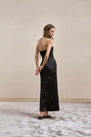 Black Axis gown by Yassmin Saleh with flowing fabric and elegant design, shown from the back.