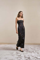 Black AXIS gown by YASSMIN SALEH shown from the side, featuring elegant flowing fabric and sophisticated design.