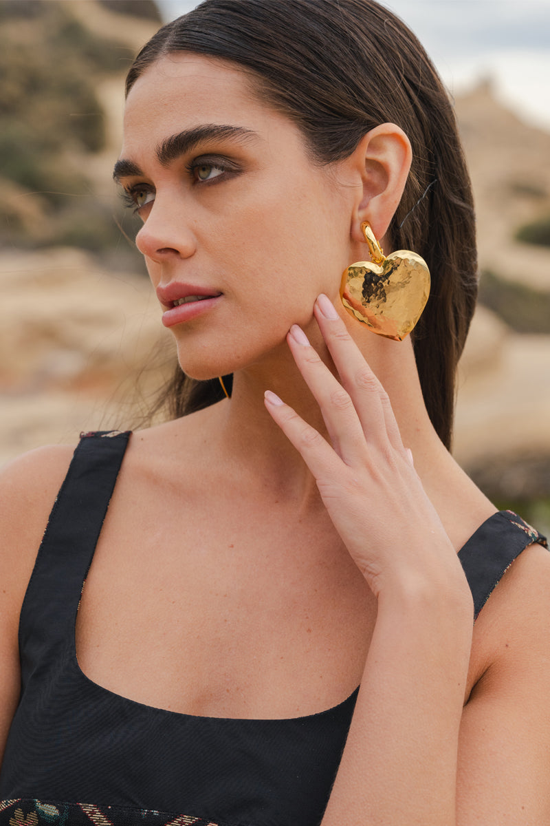 Jessica K B.O Cora Gold Earrings, shiny hoop earrings with elegant design, showcased on a neutral background.
