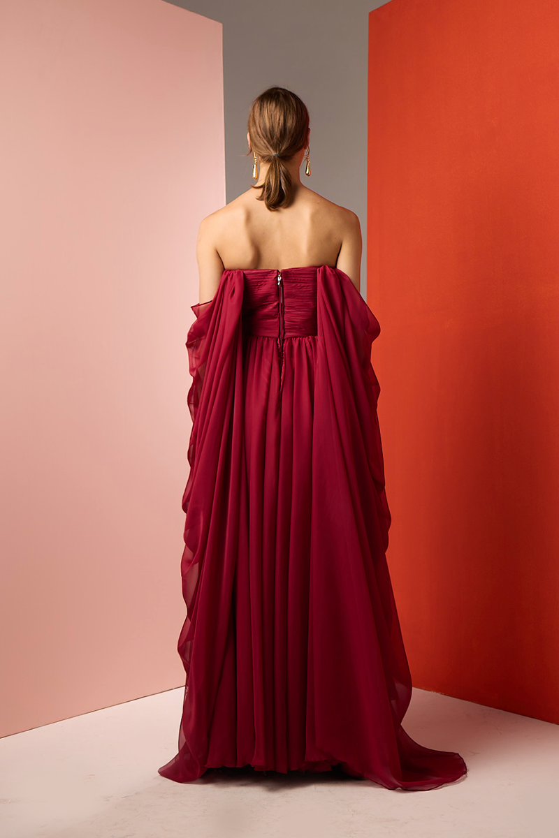 Red strapless gown by Joanna Andraos, shown from the back with elegant draping and fitted bodice.