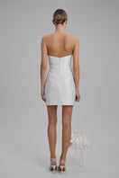 White BAÉ mini dress with a large bow at the waist, featuring a stylish and elegant design perfect for special occasions.