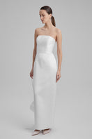 Baé Gigi White Maxi Dress with shoulder bow, flowing fabric, and elegant design, perfect for summer or special occasions.