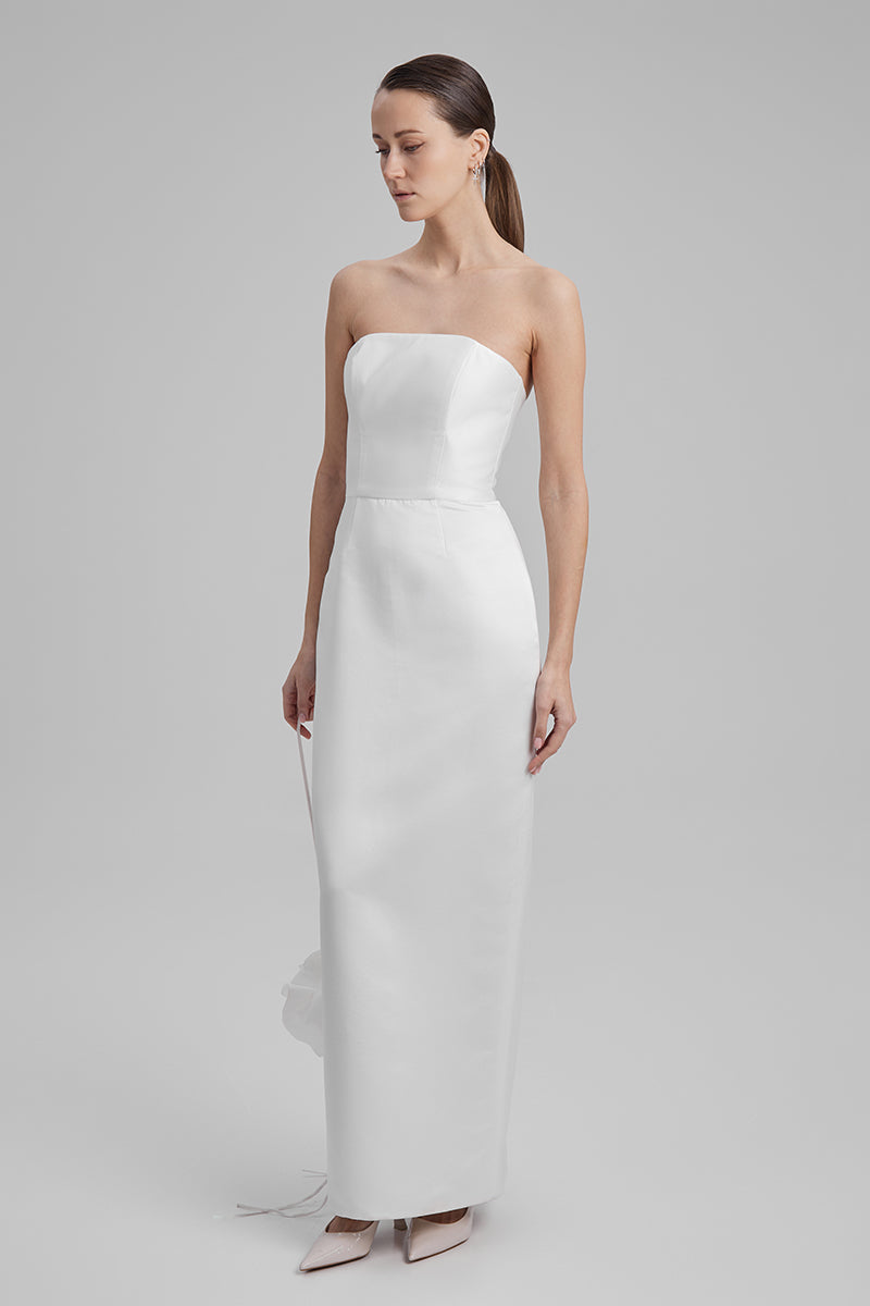 Baé Gigi White Maxi Dress with shoulder bow, flowing fabric, and elegant design, perfect for summer or special occasions.